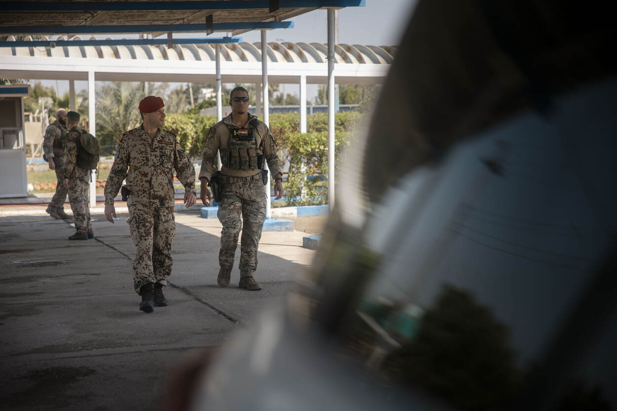 Duitse officier met een Nederlandse bodyguard loopt richting auto.