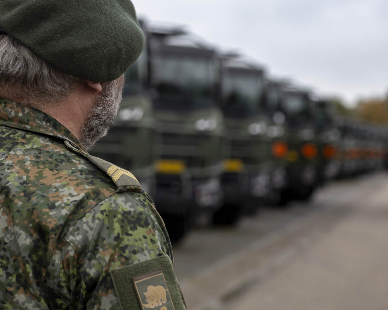 Een reservist staat bij lesauto’s.