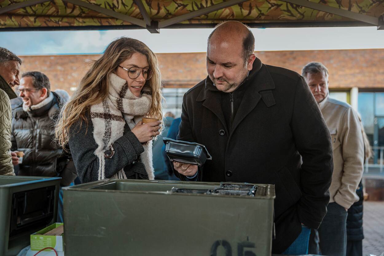een man en een vrouw die geïnteresseerd naar een product uit de defensiekeuken kijken.