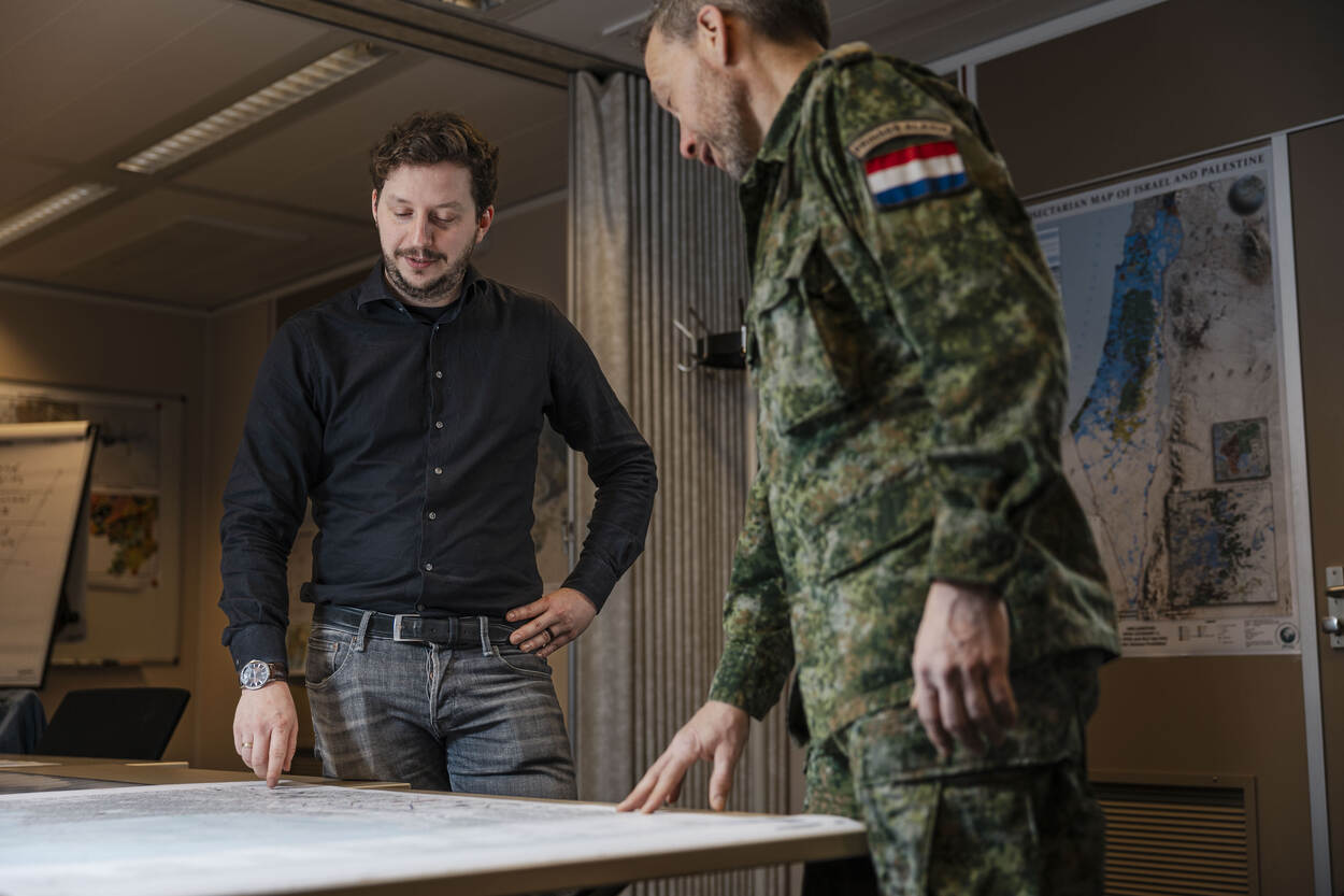 Twee medewerkers van DGeo buigen over een tafel met daarop een stafkaart.