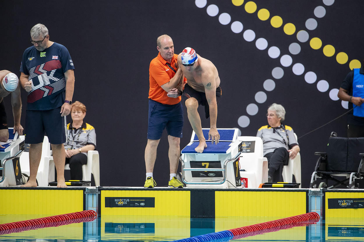Adjudant Wijnberger helpt deelnemer Edwin de Wolf op het startblok in het zwembad tijdens de Invictus Games in Toronto.