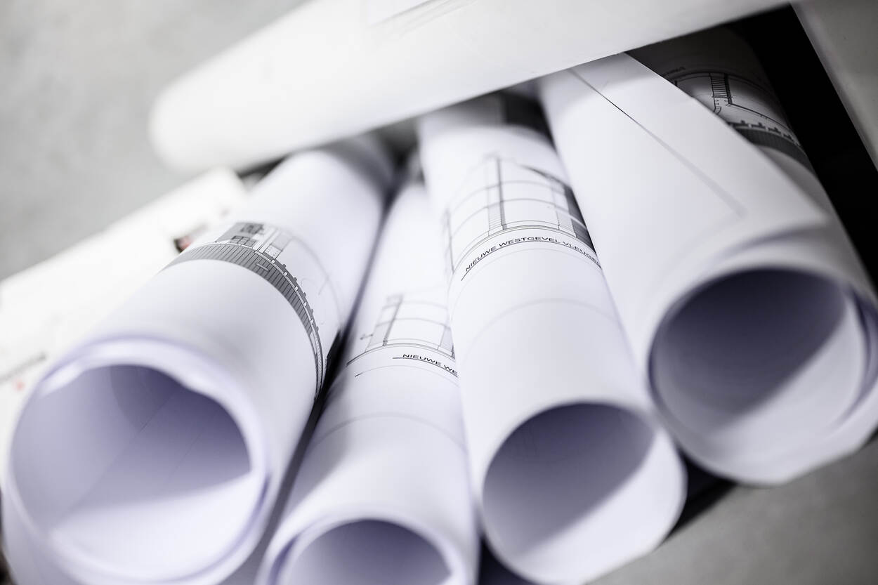 Rollen bouwtekeningen op een stapel