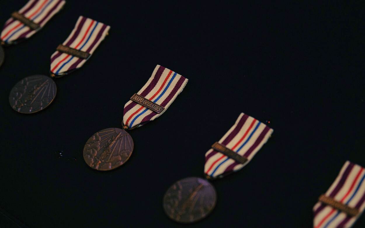 5 medailles liggen naast elkaar op een tafel.