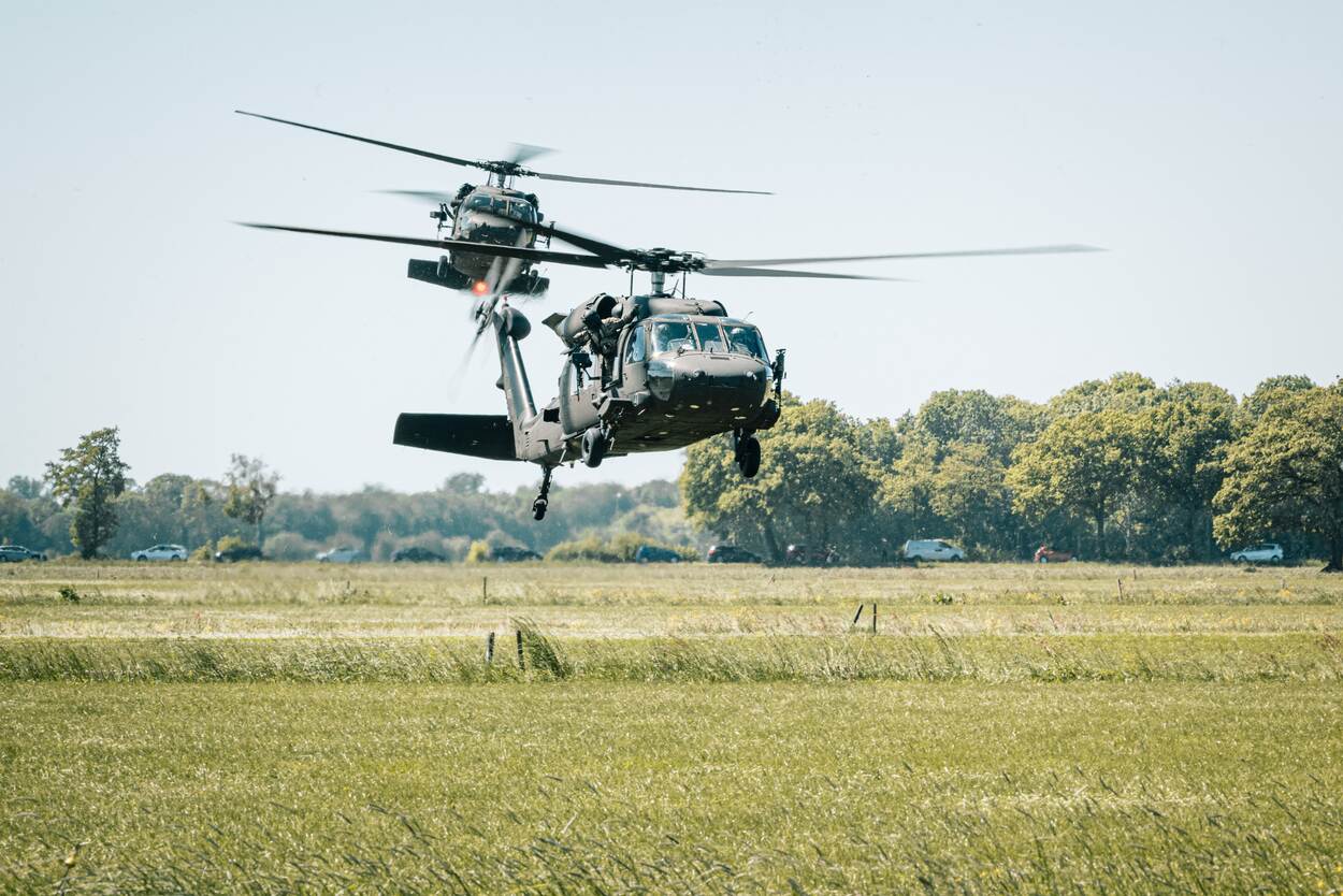 twee in het weiland landende Blackhawks.