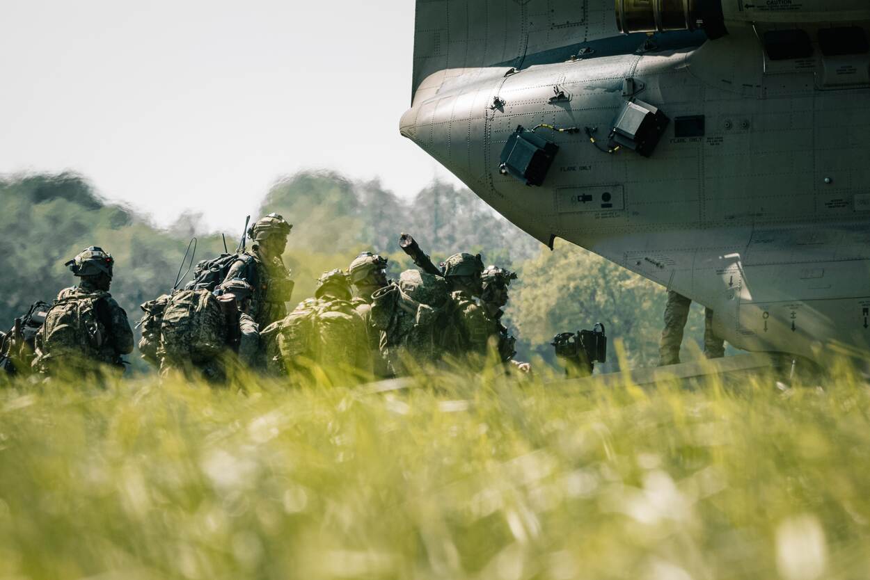 militairen die te velde achterin een Chinook stappen.