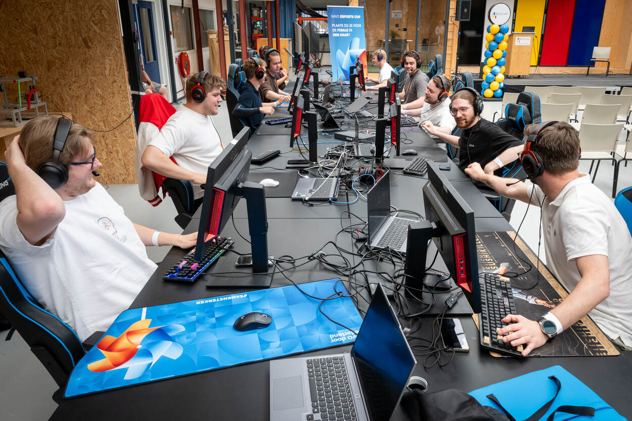 Gamers zitten tegenover elkaar achter hun PC’s.