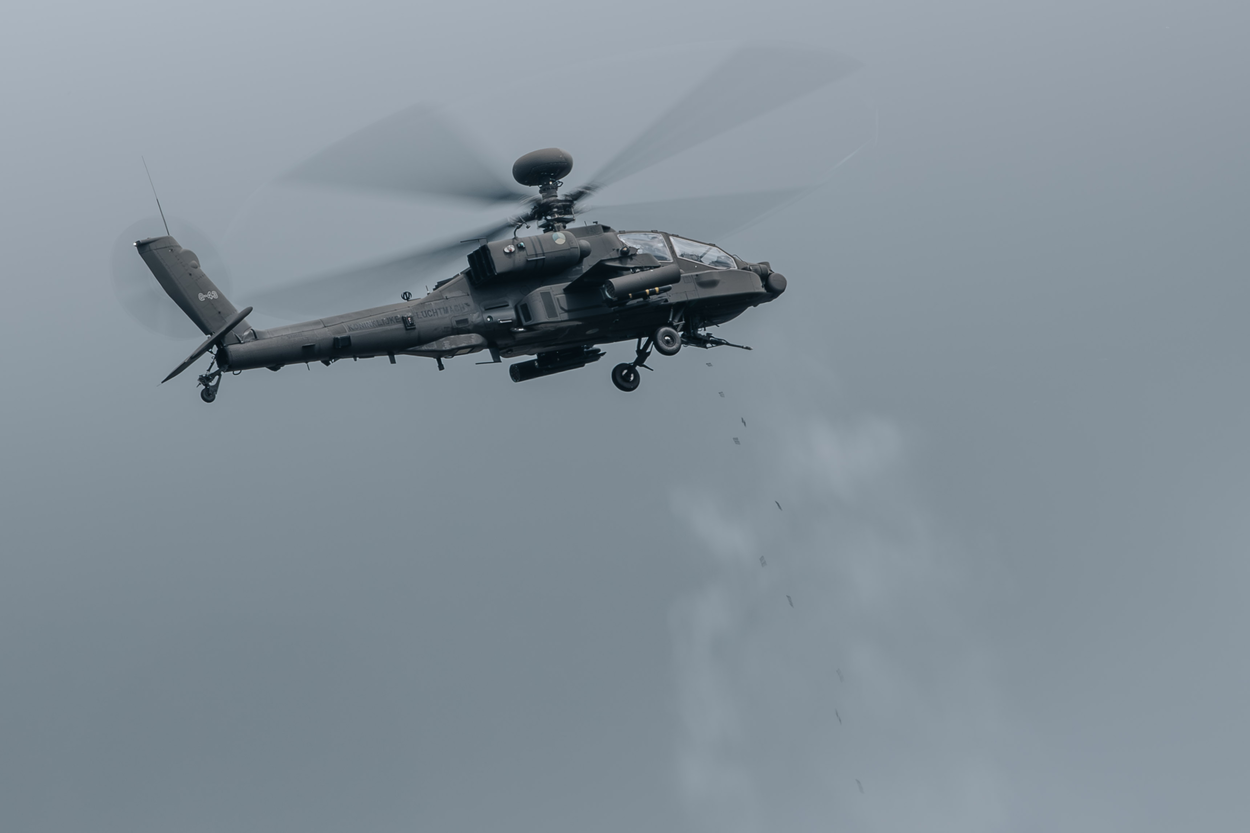 Een vliegende Apache schiet met het boordkanon.