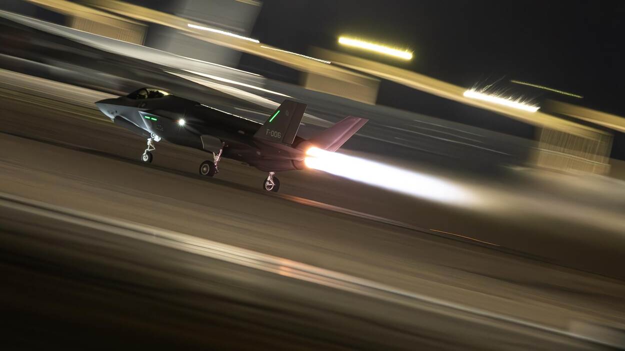 Een F-35 stijgt in het donker op, met loeiende straalmotor