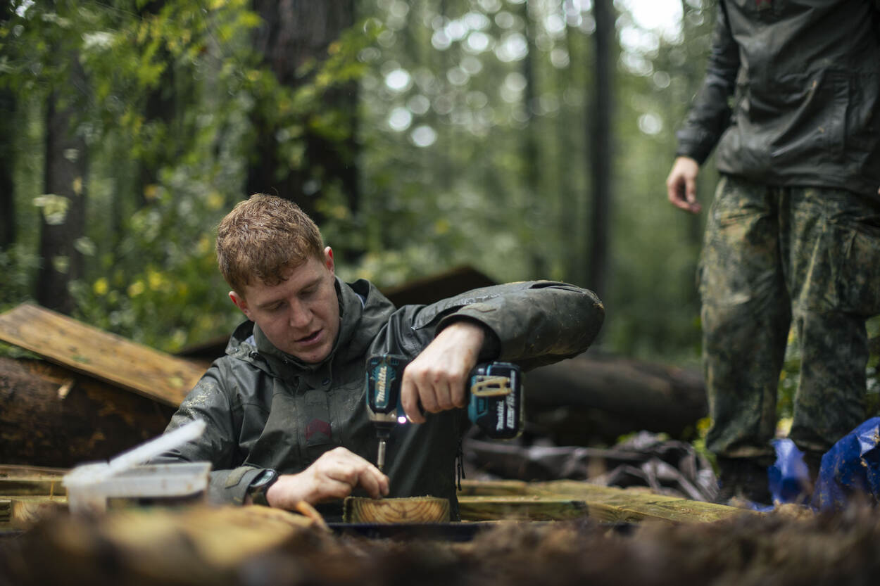 Militair boort een luik in de grond.