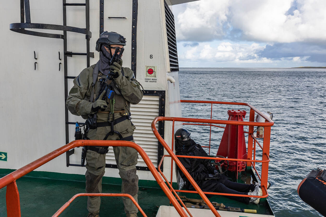 Een operator staat met zijn geweer gereed op een scheepsdek
