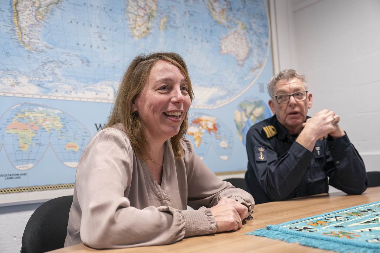 Simone Boekel en overste Cees Bruggeman samen achter een tafel met wereldkaart op de achtergrond.
