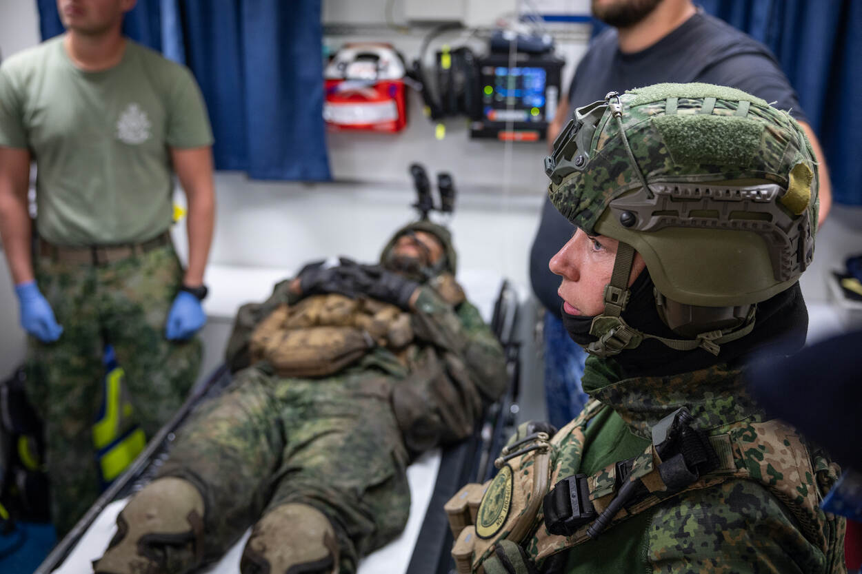 In de ziekenboeg behandelt medisch personeel een gewonde marinier.