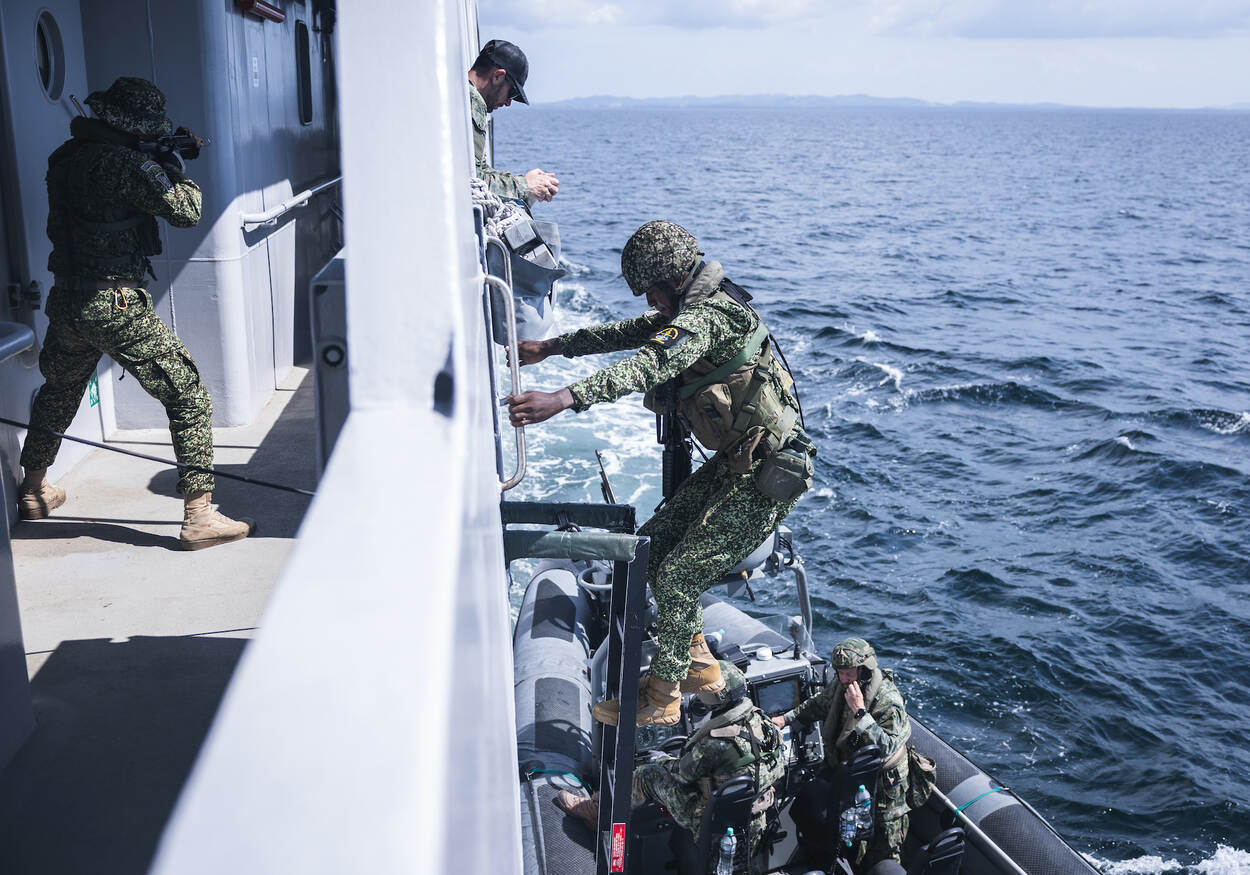 Colombiaanse mariniers klimmen aan boord via een touwladder.