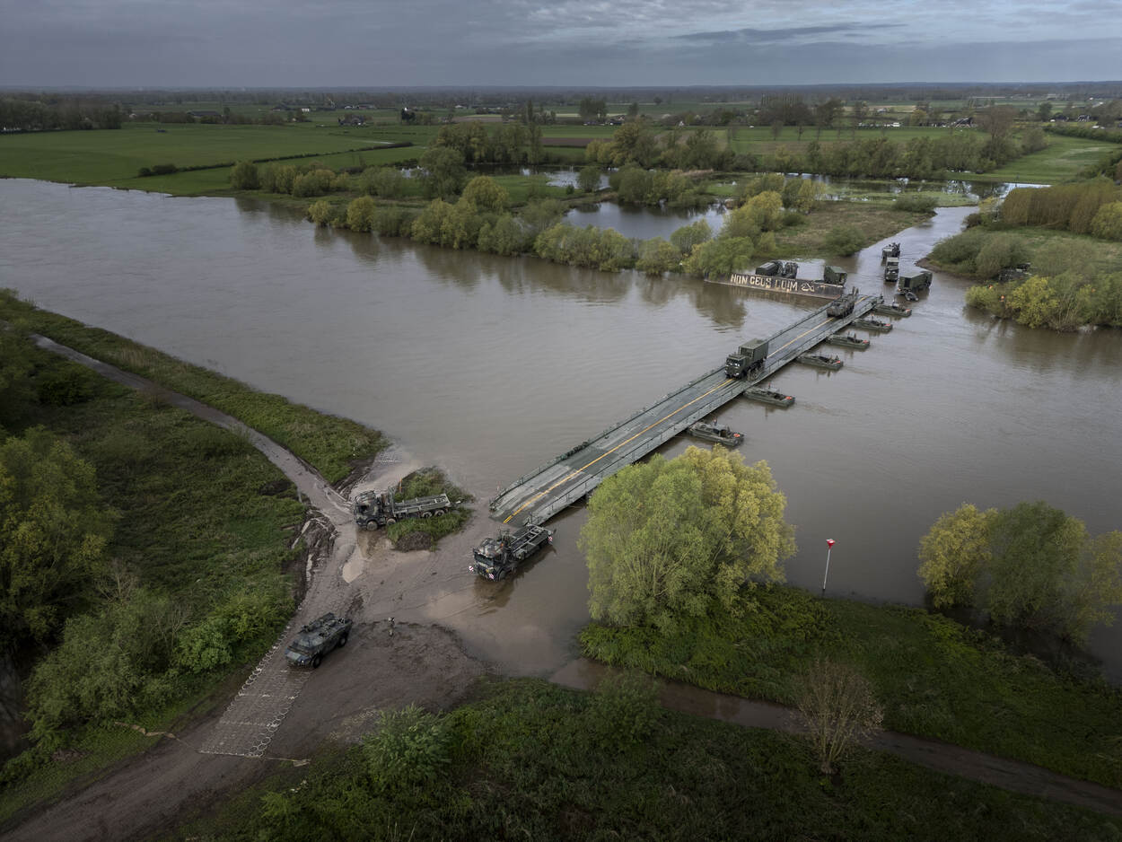 Voertuigen rijden over de brug die de genisten over de IJssel gemaakt hebben.