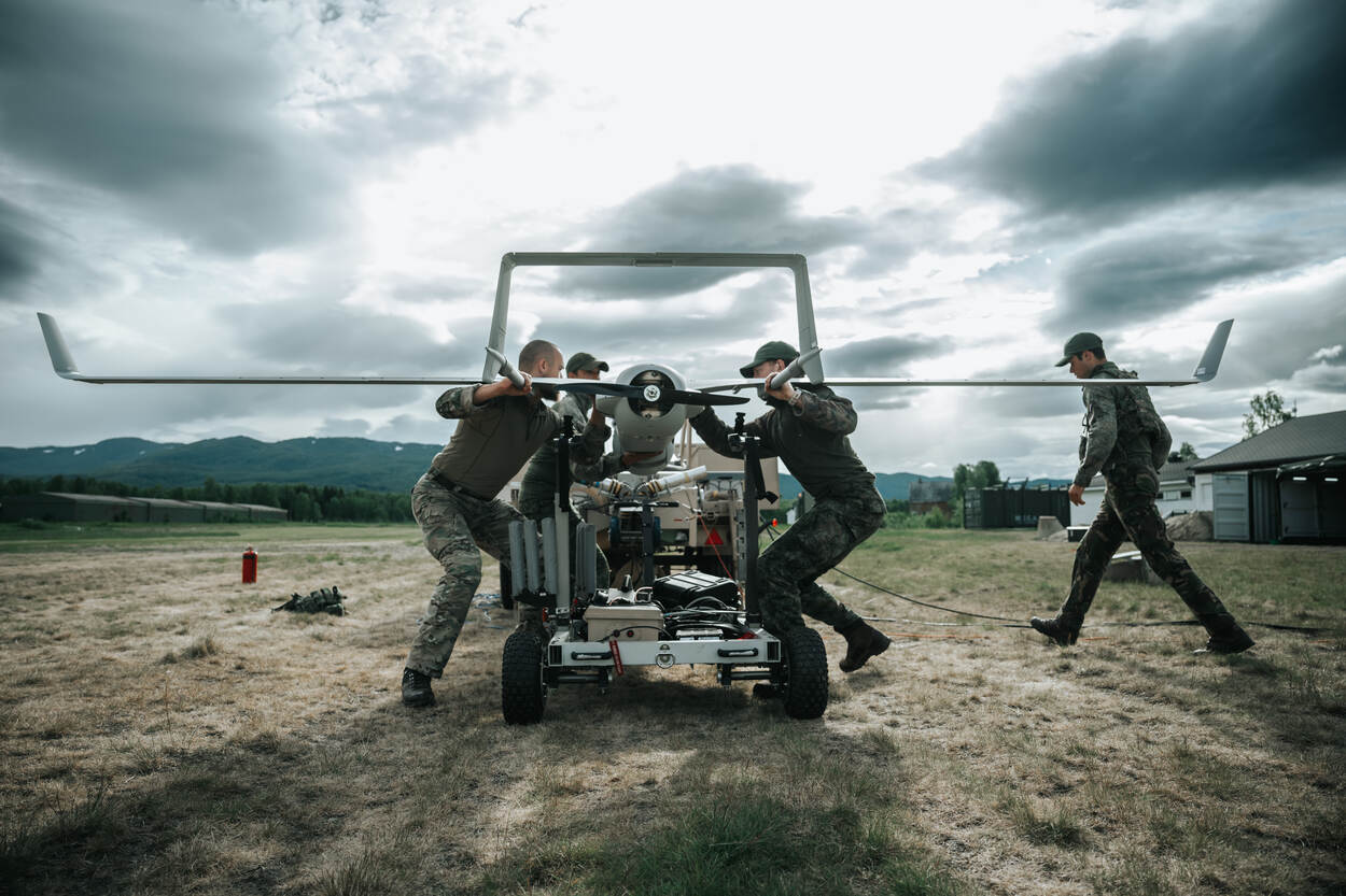 Militairen buigen zich over een klein vliegtuig in het oefengebied in Noorwegen. Het betreft de X-300 Integrator, een onbemand vliegsysteem.