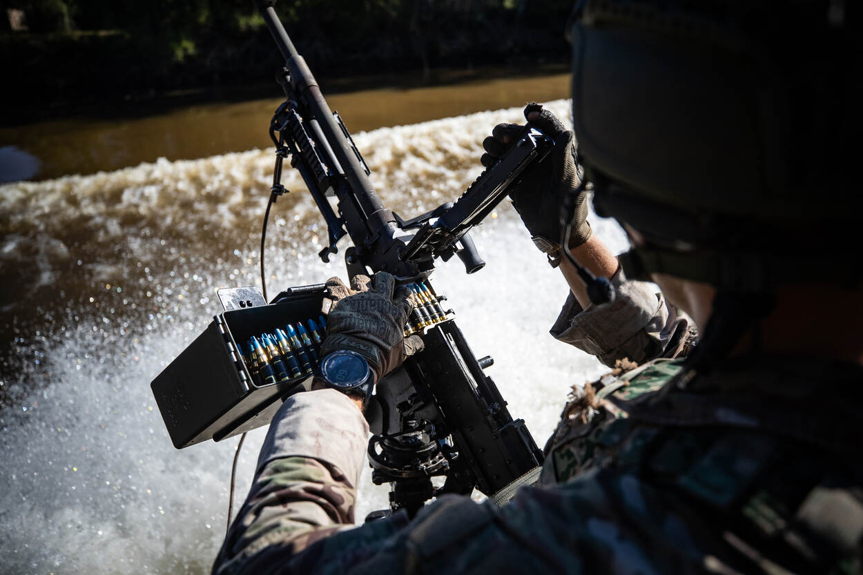 Een militair op een boot met een wapen.