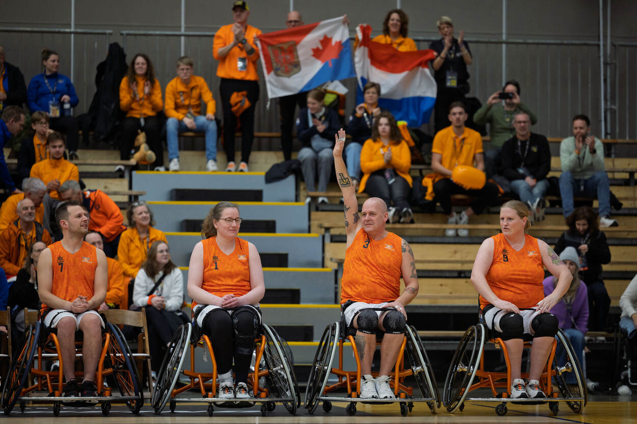 André Meulemans zwaait vanuit zijn rolstoel naar het publiek.