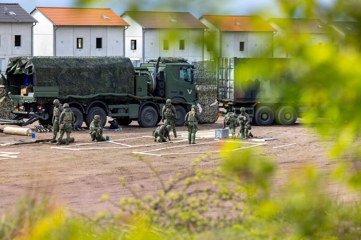 Militairen maken zich gereed op oefenterrein.