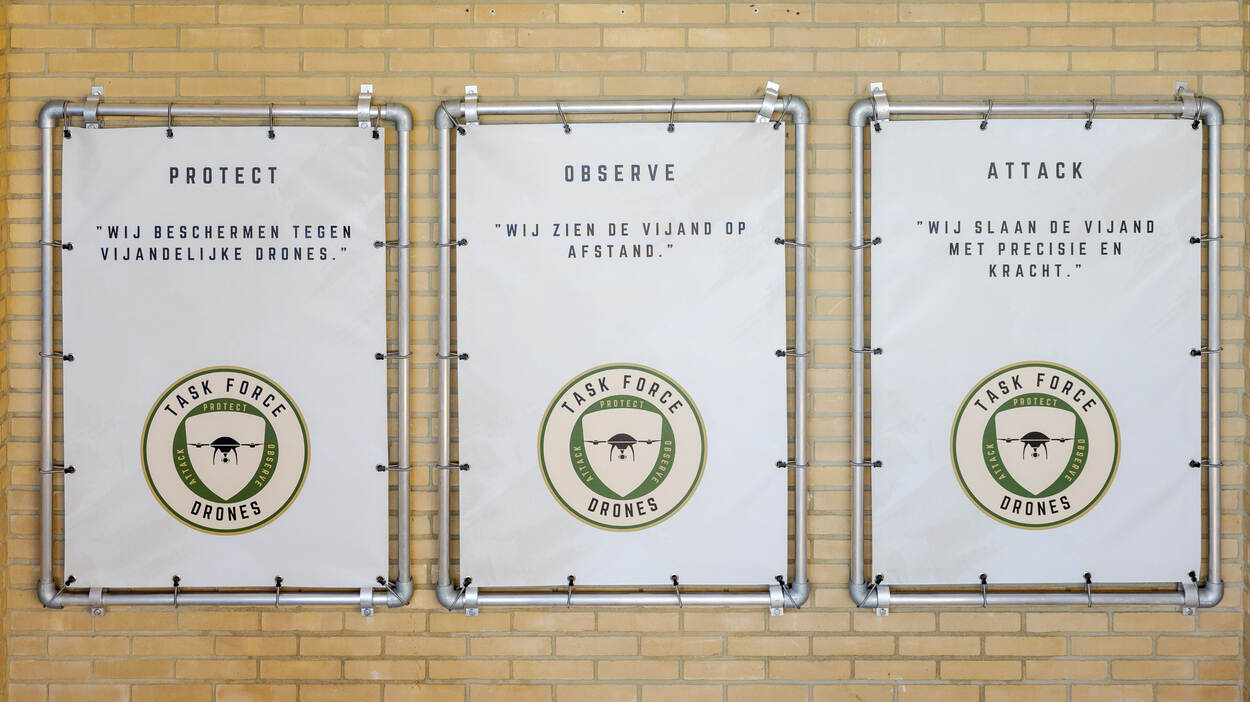 Drie borden hangen aan een muur. Daarop staat: protect, observe en attack. Oftewel: beschermen, observeren en aanvallen. De drie pijlers van de taskforce hangen in de gang van hun gebouw op de Tonnetkazerne in ’t Harde.
