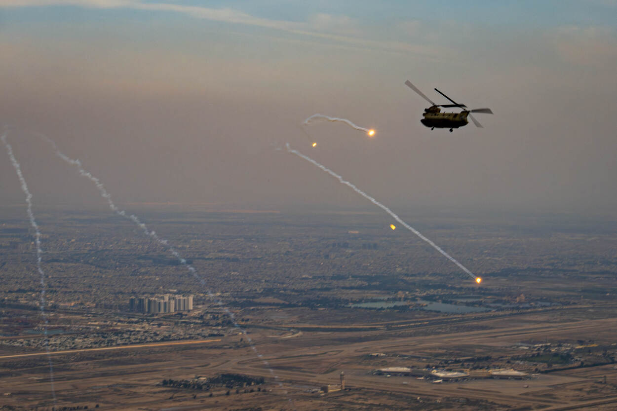 Een Nederlandse Chinook-transporthelikopter schiet flares af boven Irak.
