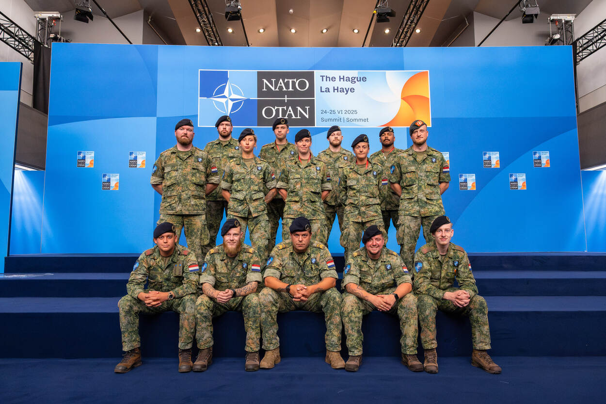 Eenheid 2Ciscoy poseert op podium met op achtergrond NAVO-logo.