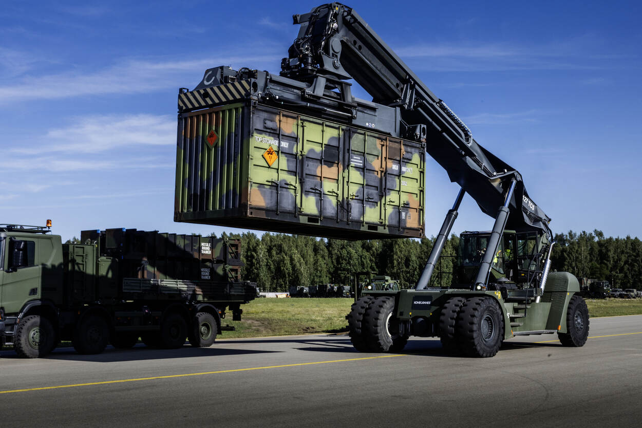 Een militaire containerkraan die een 20 voets-container verrijdt.