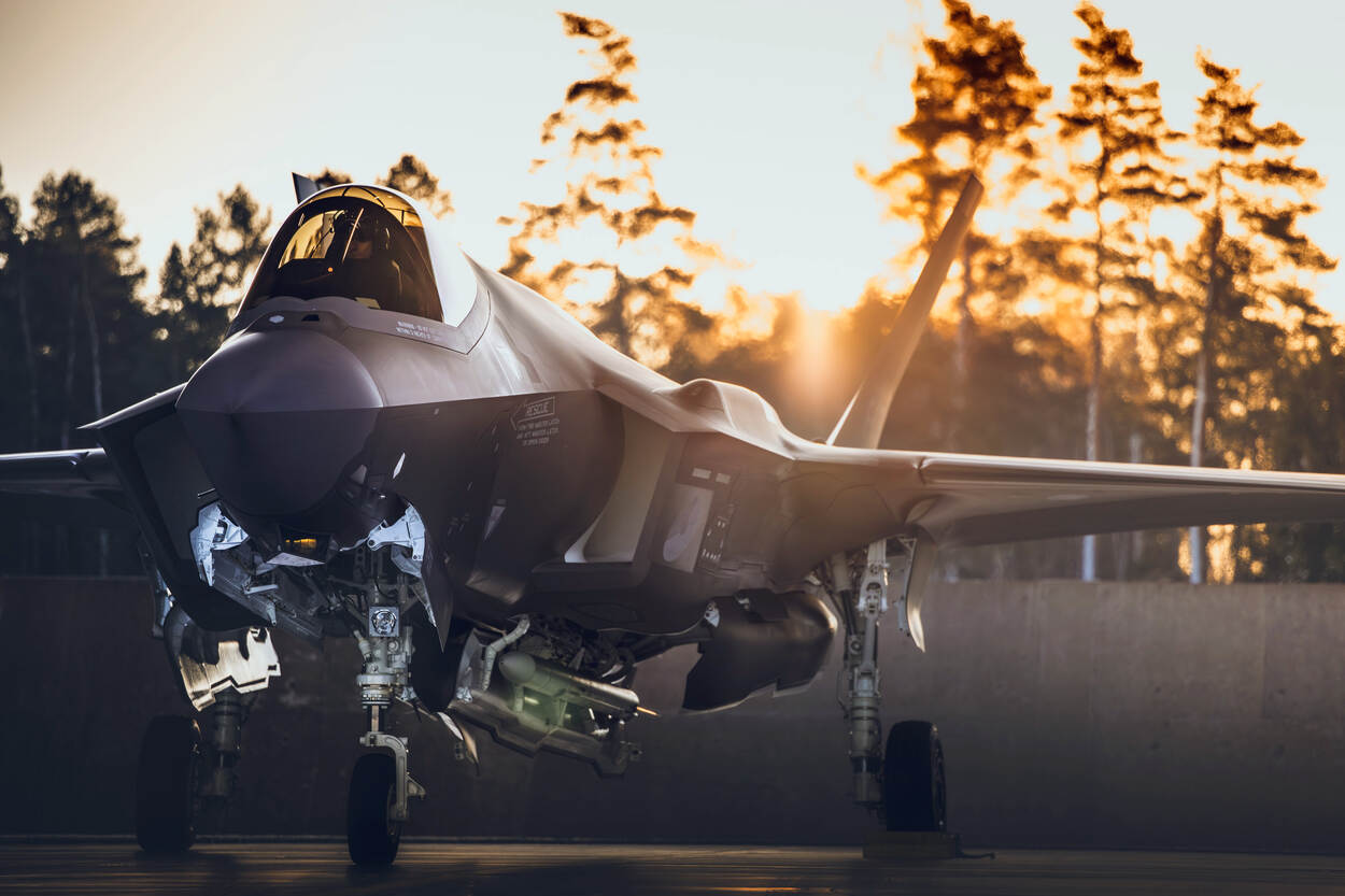 Een stilstaande F-35 met op de achtergrond licht van de ondergaande zon.