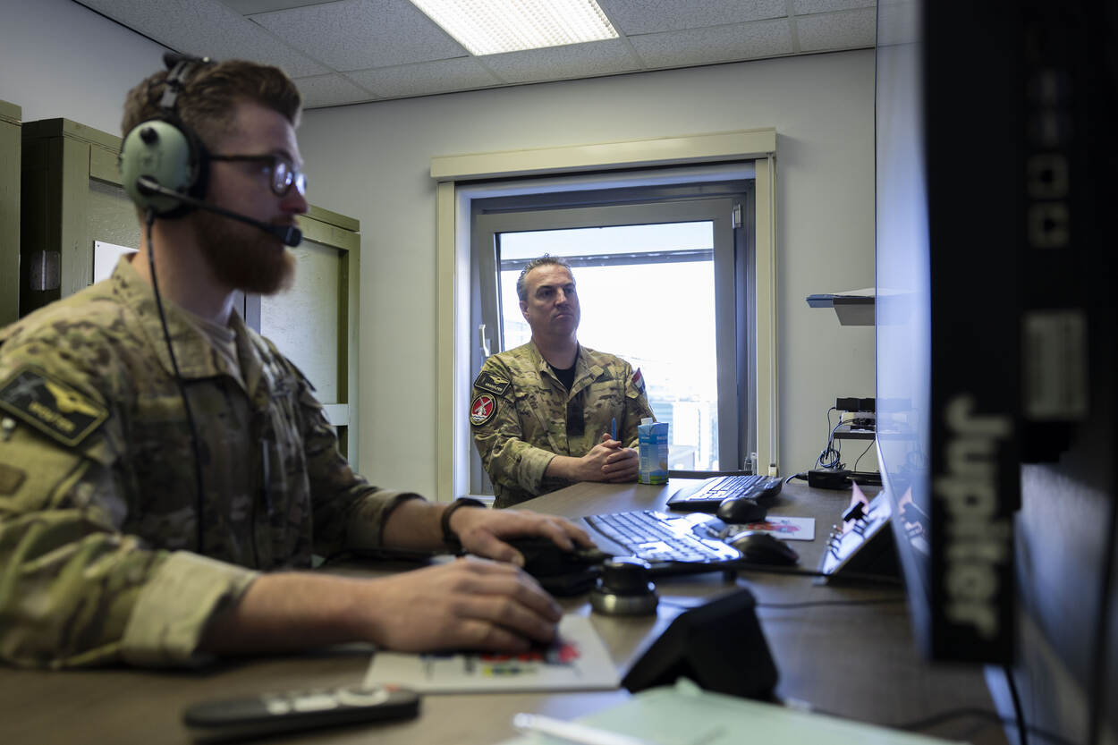 Sergeant-majoor Dennis kijkt mee naar het grote computerscherm.