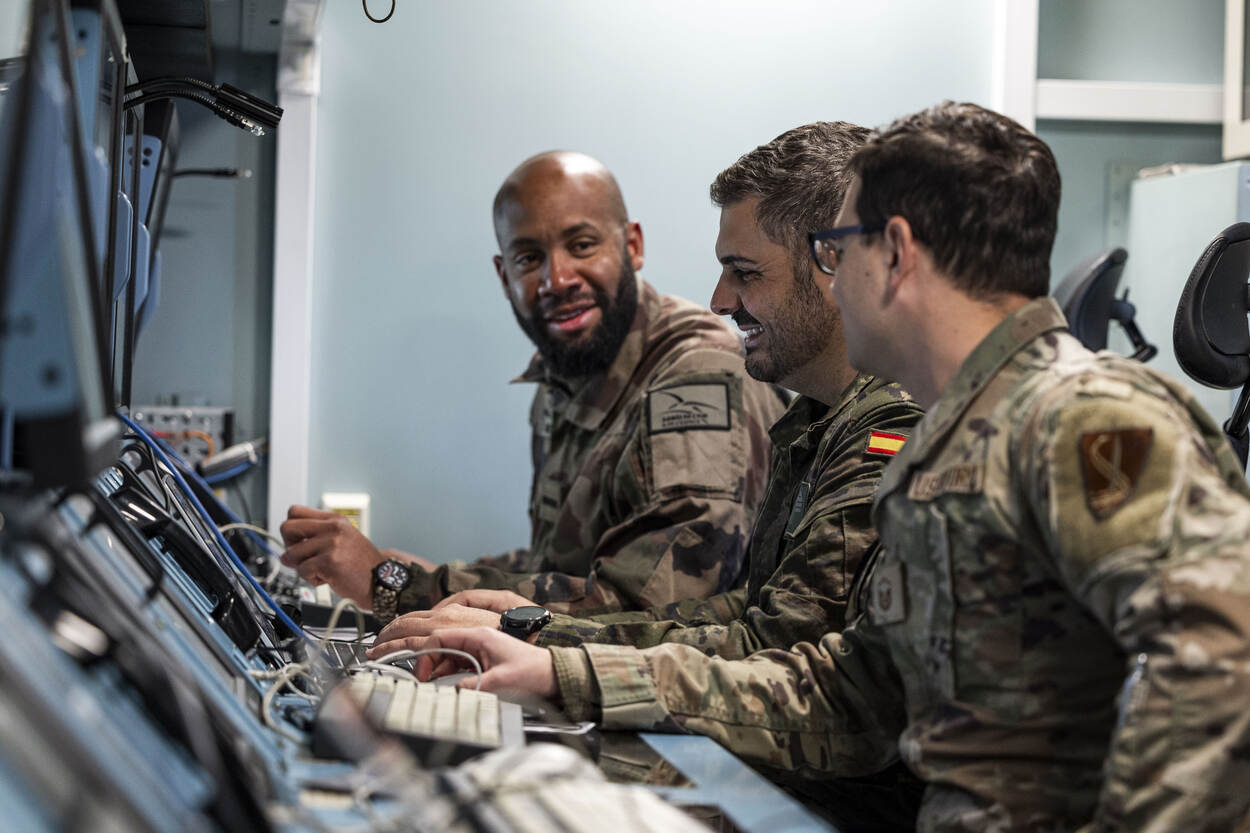 Binnen in een container overleggen een Franse, een Spaanse en een Amerikaanse militair van DACCC.
