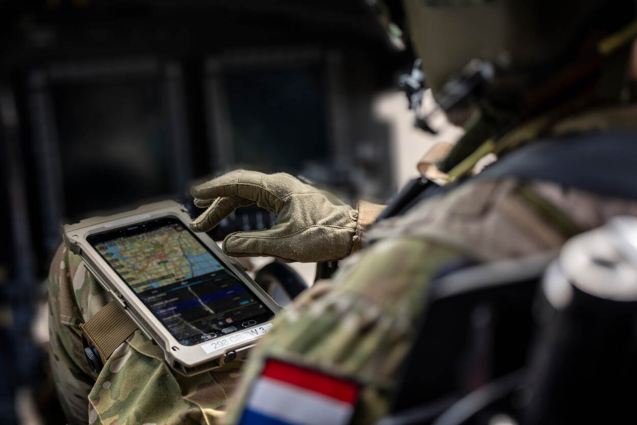 Vlieger zittend in cockpit met tablet op de been bevestigd.