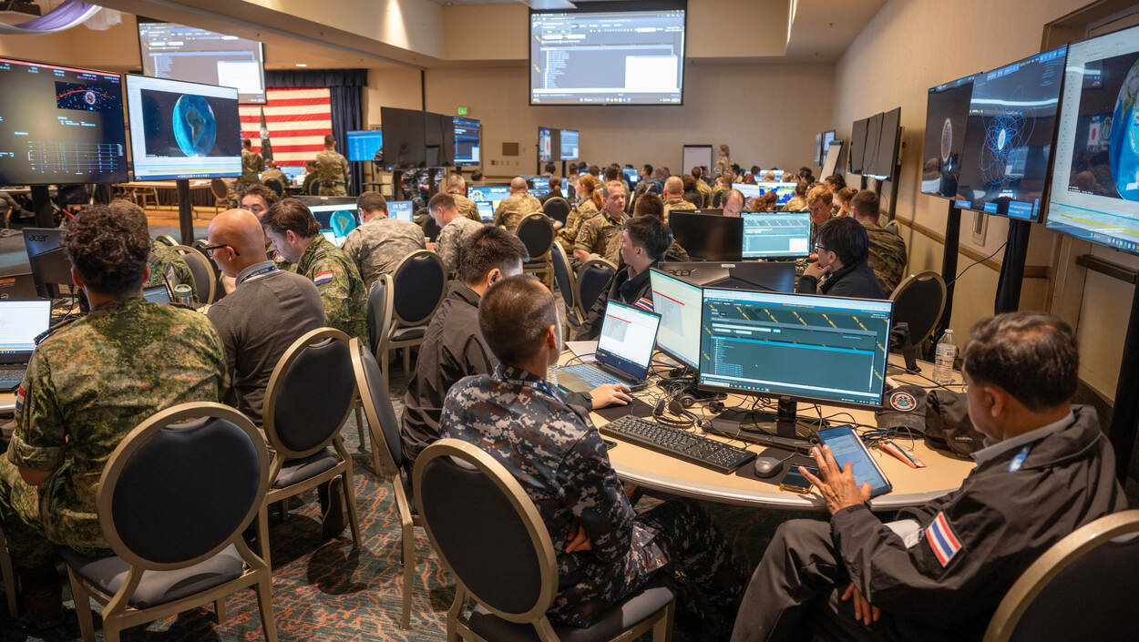 Beeld van een zaal waar overal groepjes mensen aan een tafel zitten.