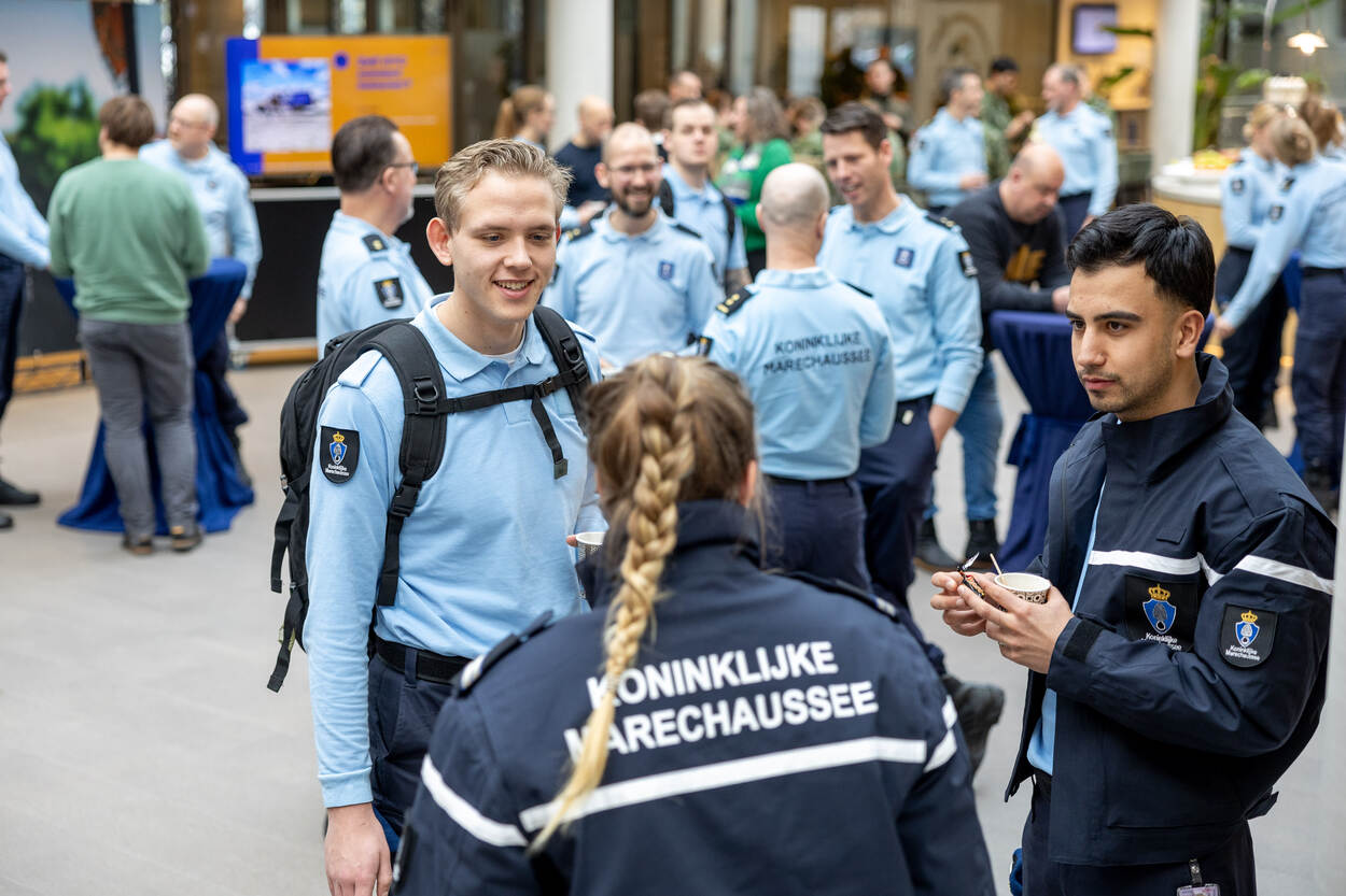 Medewerkers van de Koninklijke Marechaussee met elkaar in gesprek.