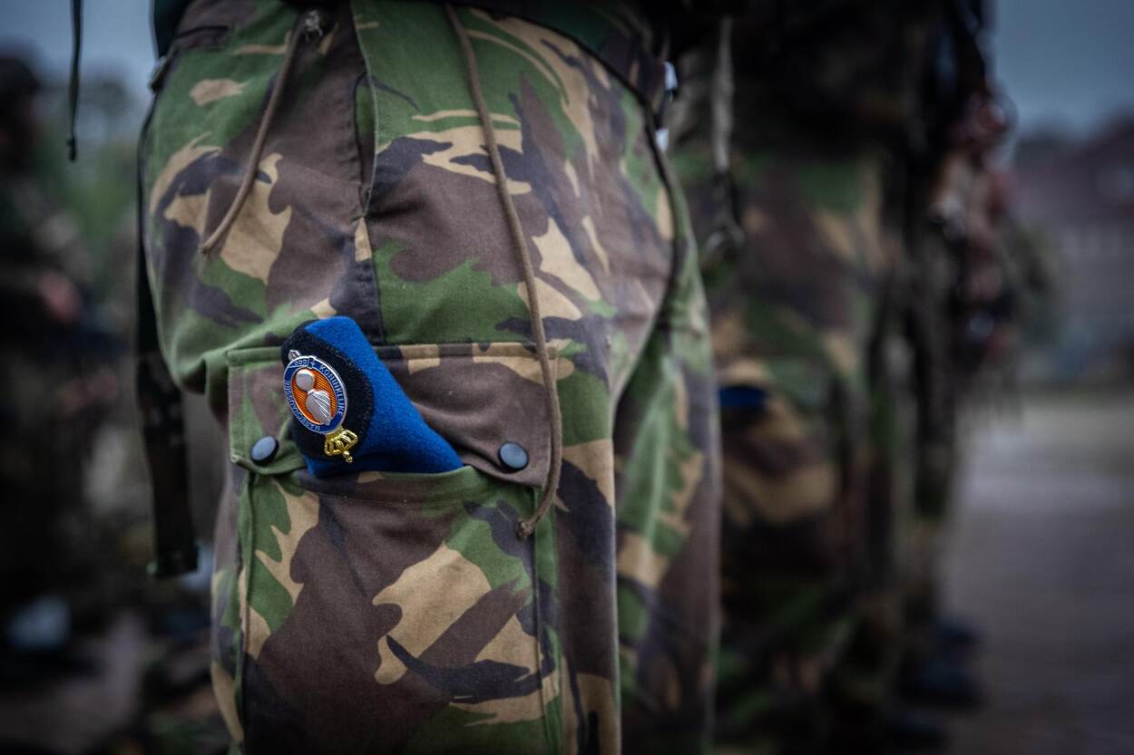 Blauwe baret van de Marechaussee in een groene, militaire broek.