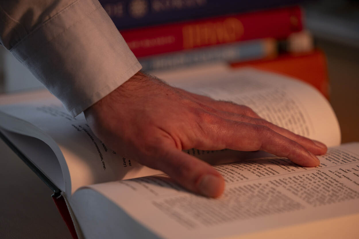 Een hand wijst iets aan in de Koran.