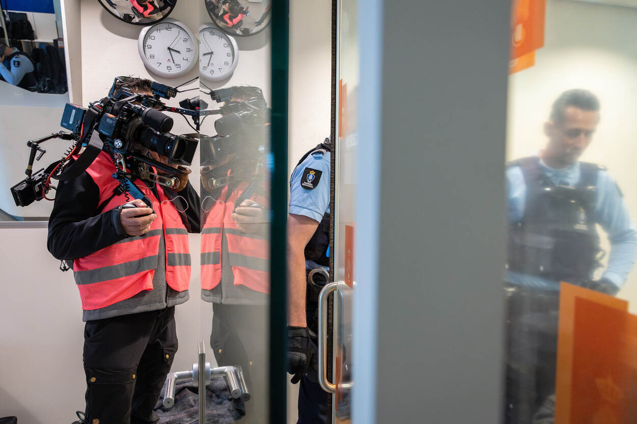 Marechaussee en cameraman op Schiphol.