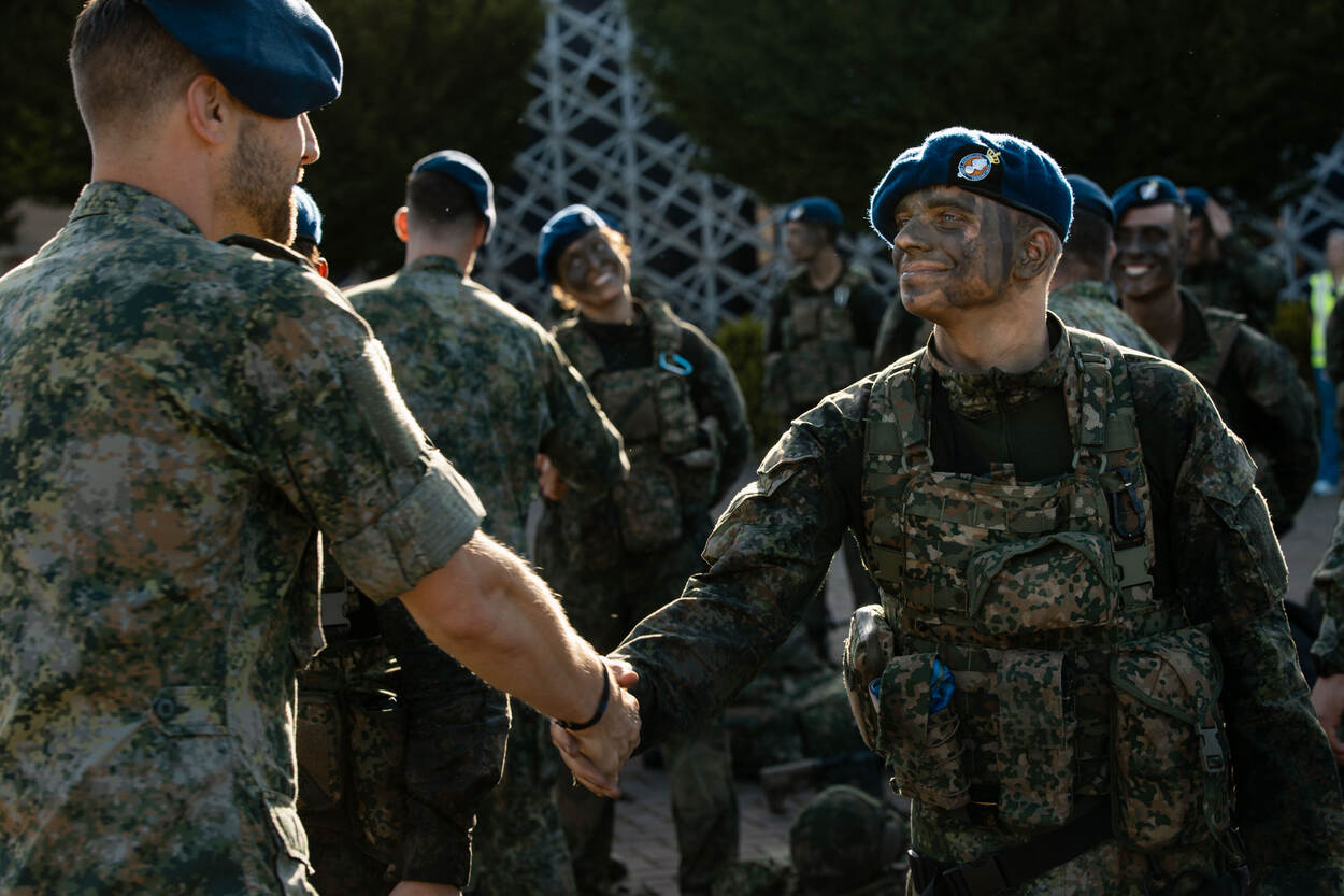 Een instructeur schudt een student de hand.