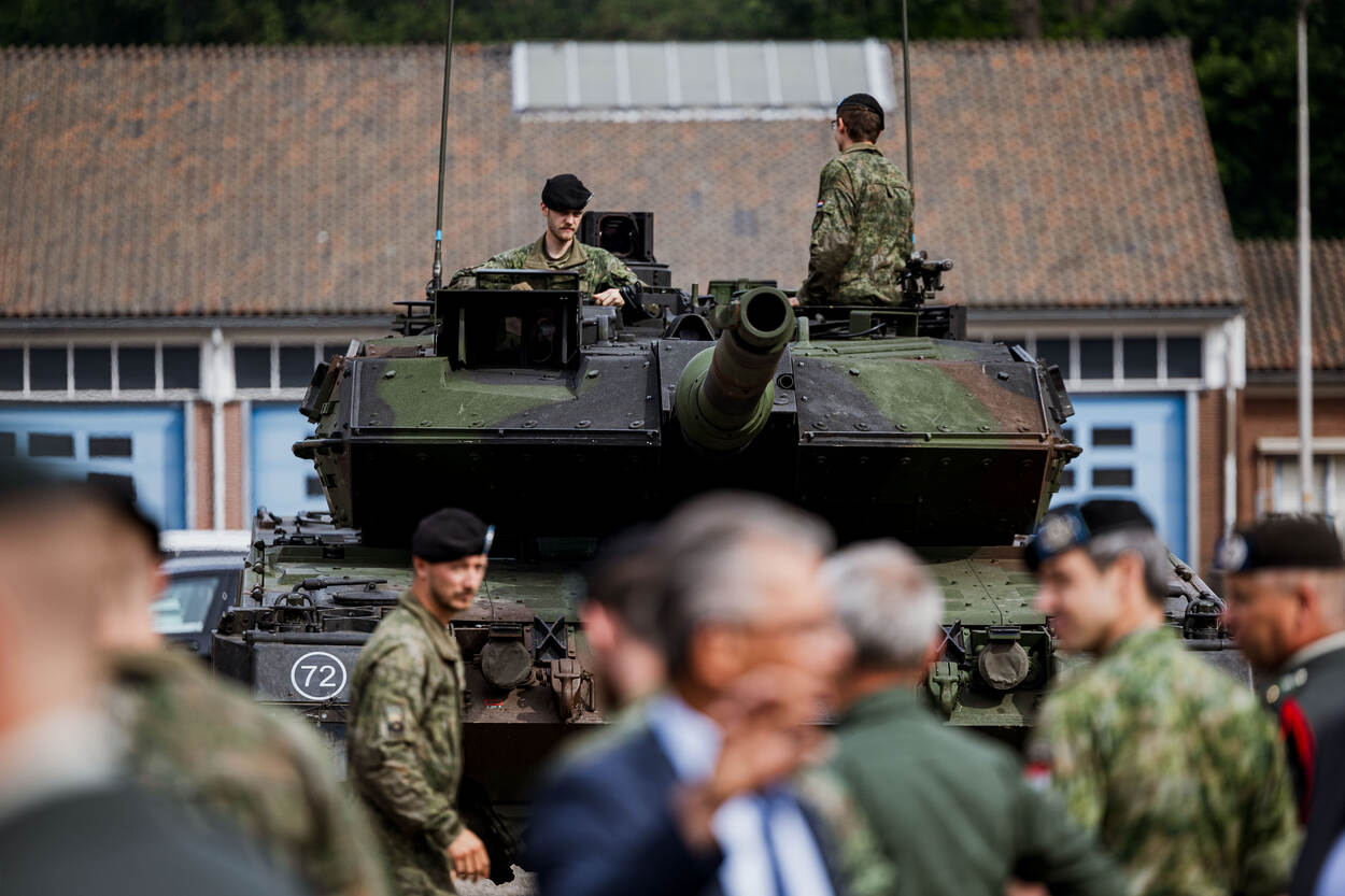 Een gevechtstank met bemanning staat op de Bernardkazerne in Amersfoort. Ervoor lopen militairen.