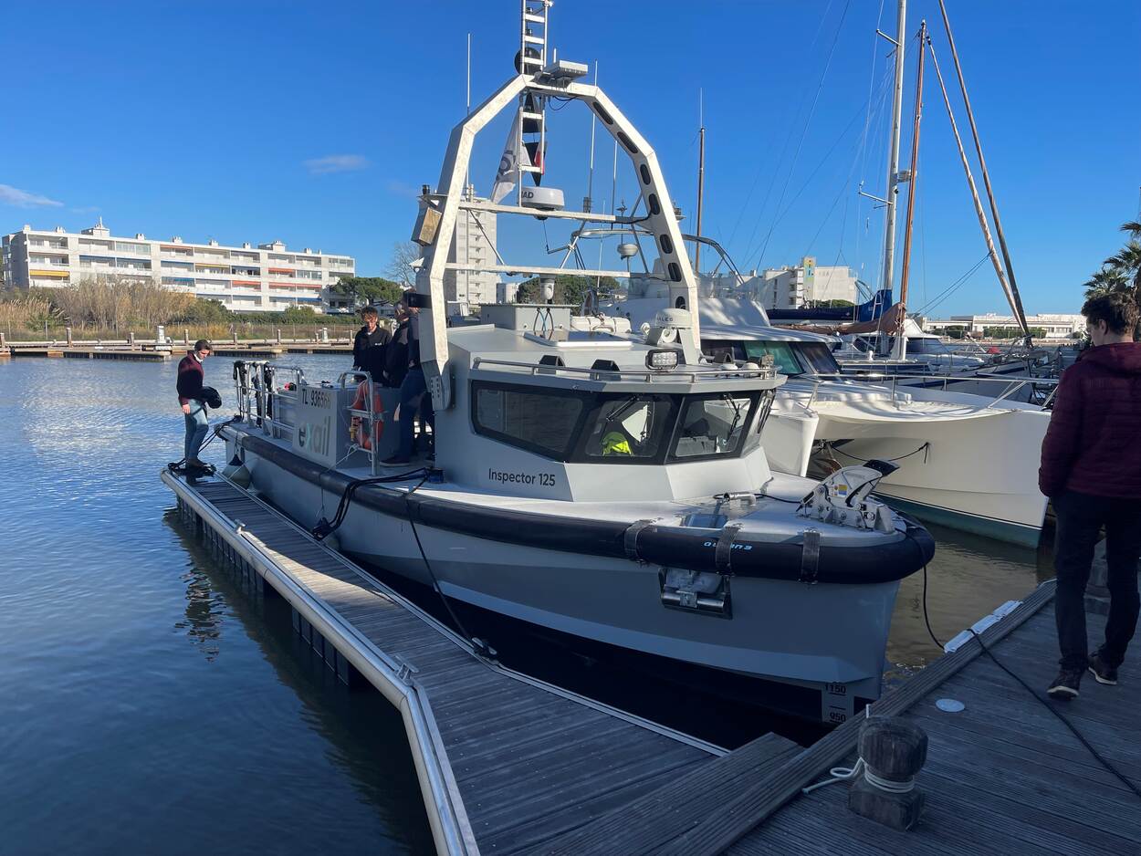 Een op afstand bestuurbare boot ligt in een haven aan de kade.