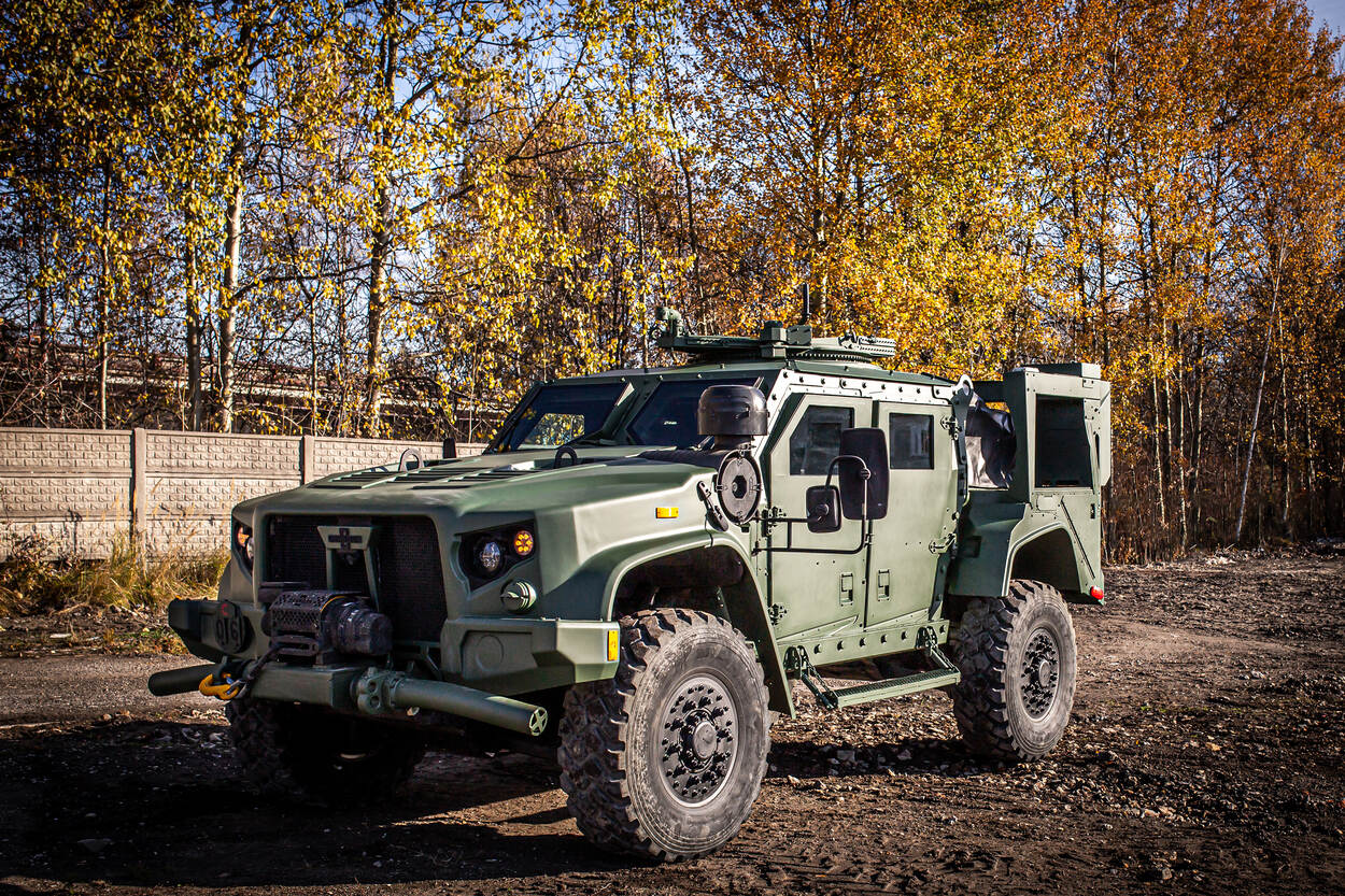 Het groene wielvoertuig de Kaaiman staat op een ondergrond van modder en stenen.