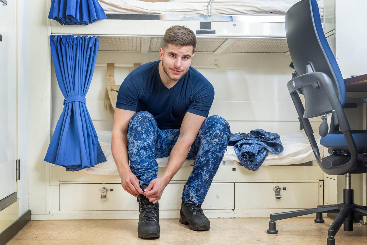 Een marineman in het nieuwe uniform poseert voor de camera.