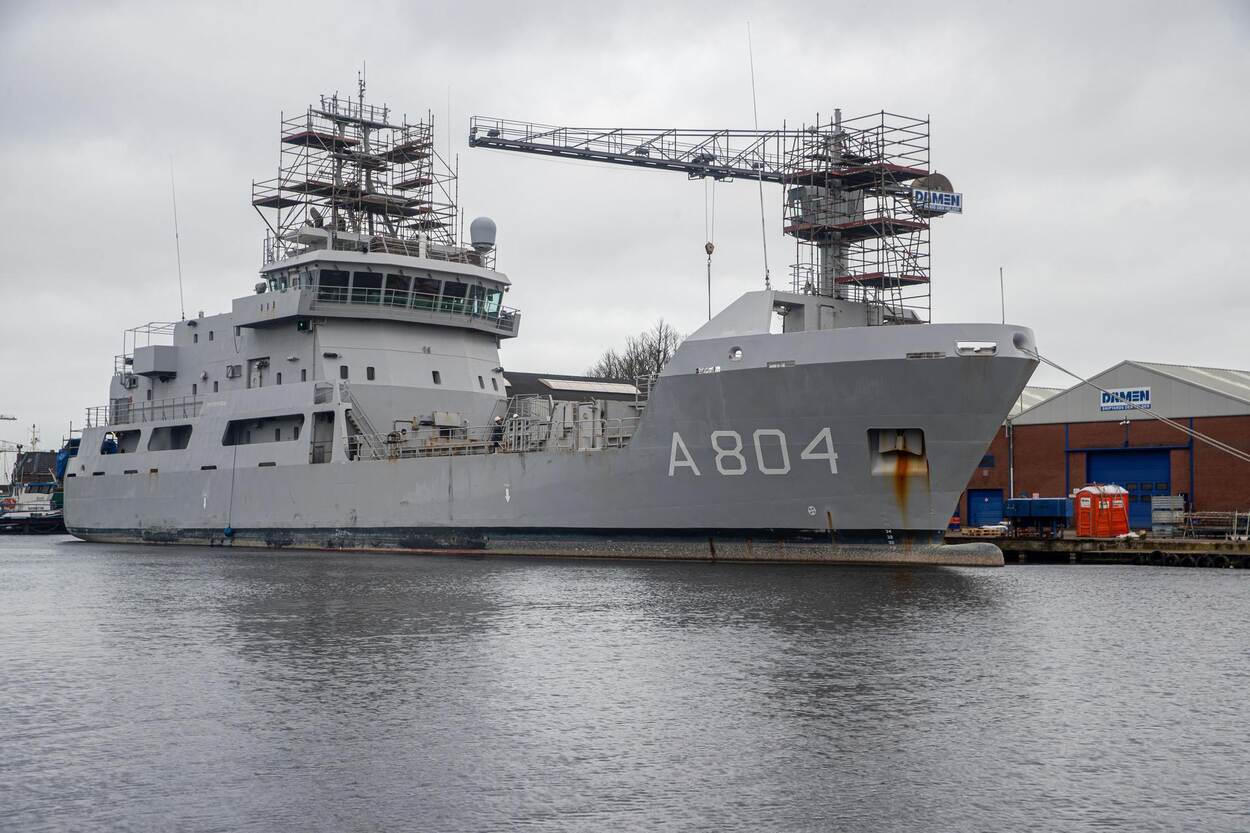 Zr.Ms. Pelikaan afgemeerd bij een werf. Een deel van de opbouw is omgeven door steigers in verband met onderhoud.