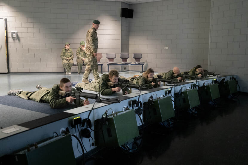 Op de foto zie je fractiemedewerkers in de schietsimulator achter een geweer liggen.