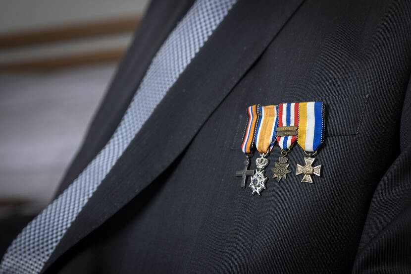 Een close-up van vier onderscheidingen op het colbert van de 98-jarige Bert Carper.