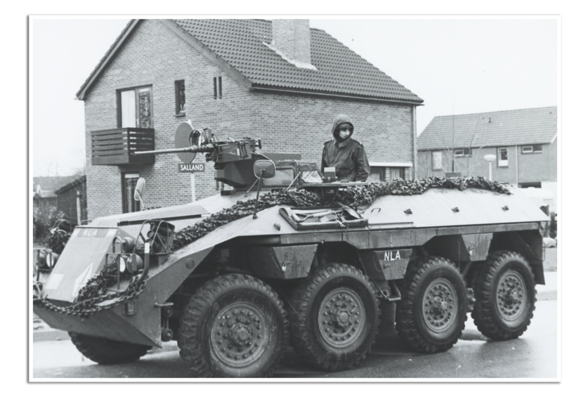 Geparkeerde pantserwagen voor een huis.