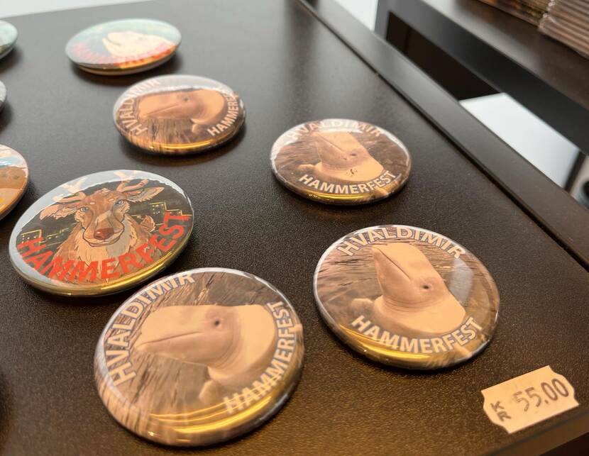 Buttons met de beeltenis van Hvaldimir liggen in een souvenirwinkel.