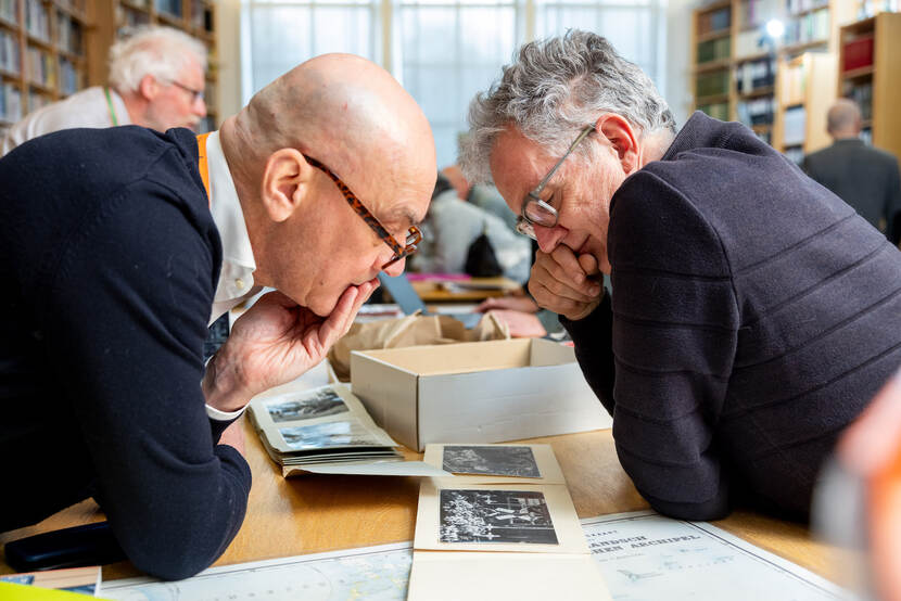 Mark Loderichs(links) van Museum Bronbeek buigt zich letterlijk over de foto’s van Nijmegenaar Wilfred.