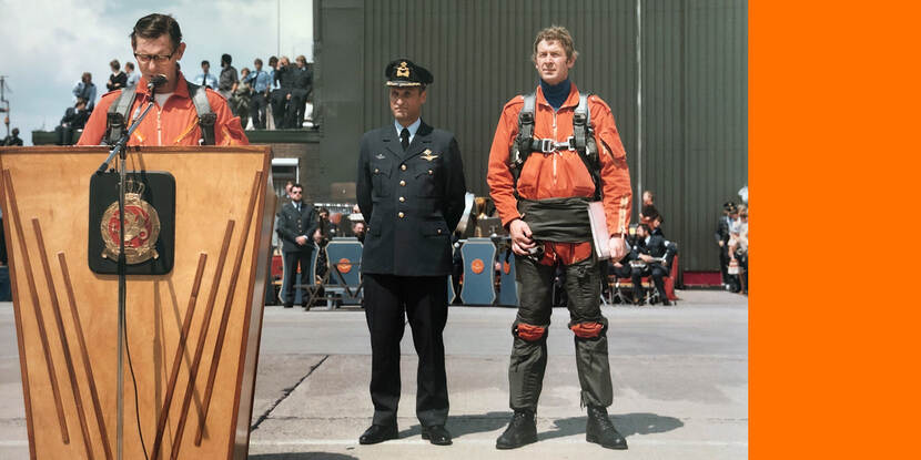Sneek in vroeger jaren, staand naast een spreekgestoelte, in een rood vliegerspak. Foto links: uit archief Sneek