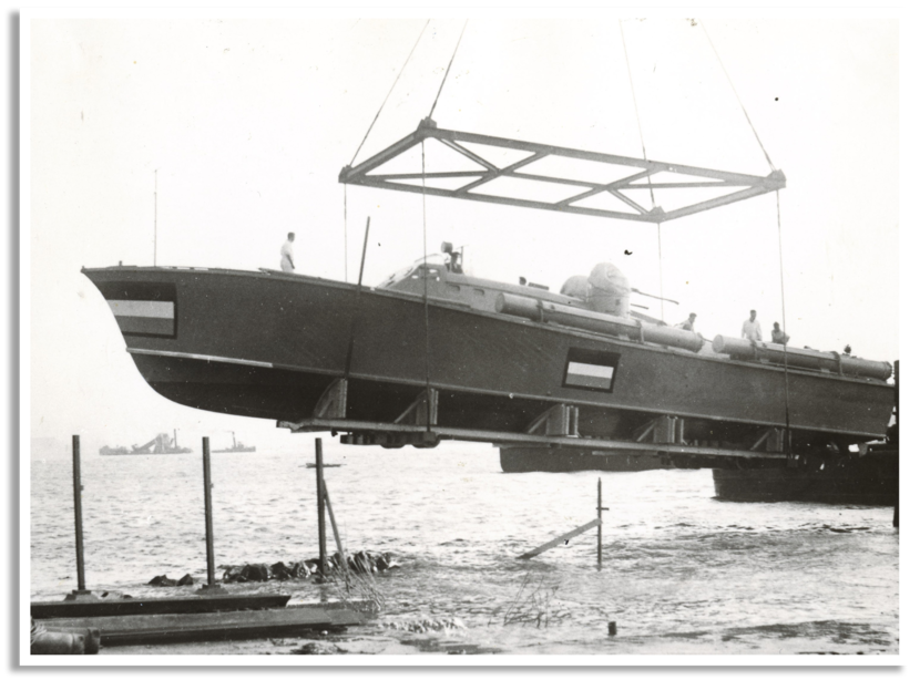 De TM51 werd op de werf in Engeland te water gelaten. De grote vlaggen zijn aangebracht om de neutraliteit van Nederland aan te geven.