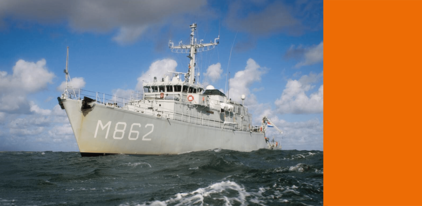 Een kraan verricht graafwerkzaamheden vanaf een plateau dat over het water ligt.