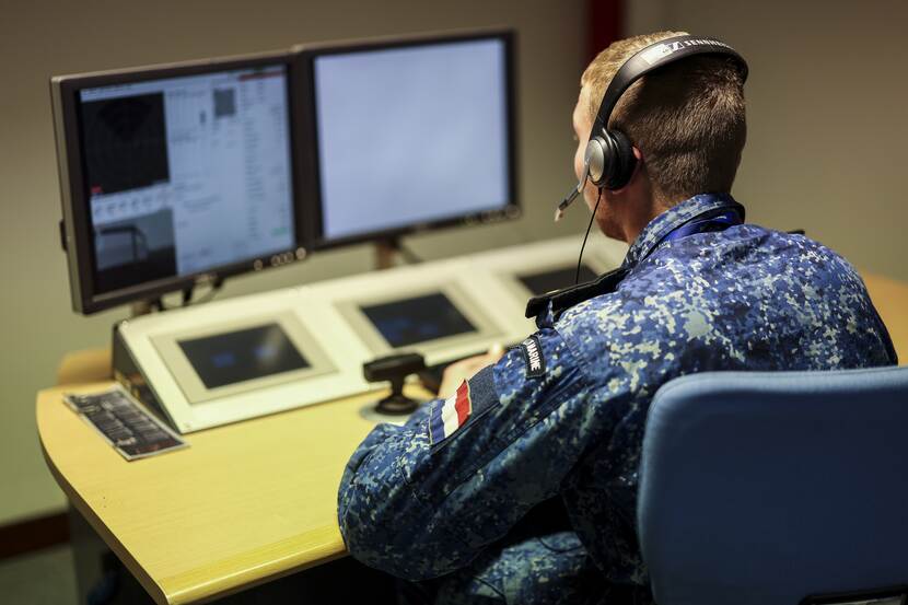 Een militair speurt op een computerscherm naar een gesimuleerde mijn.